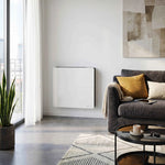 Radiateur Molia 1000W blanc dans un salon moderne, à côté d'un canapé gris et d'une grande baie vitrée